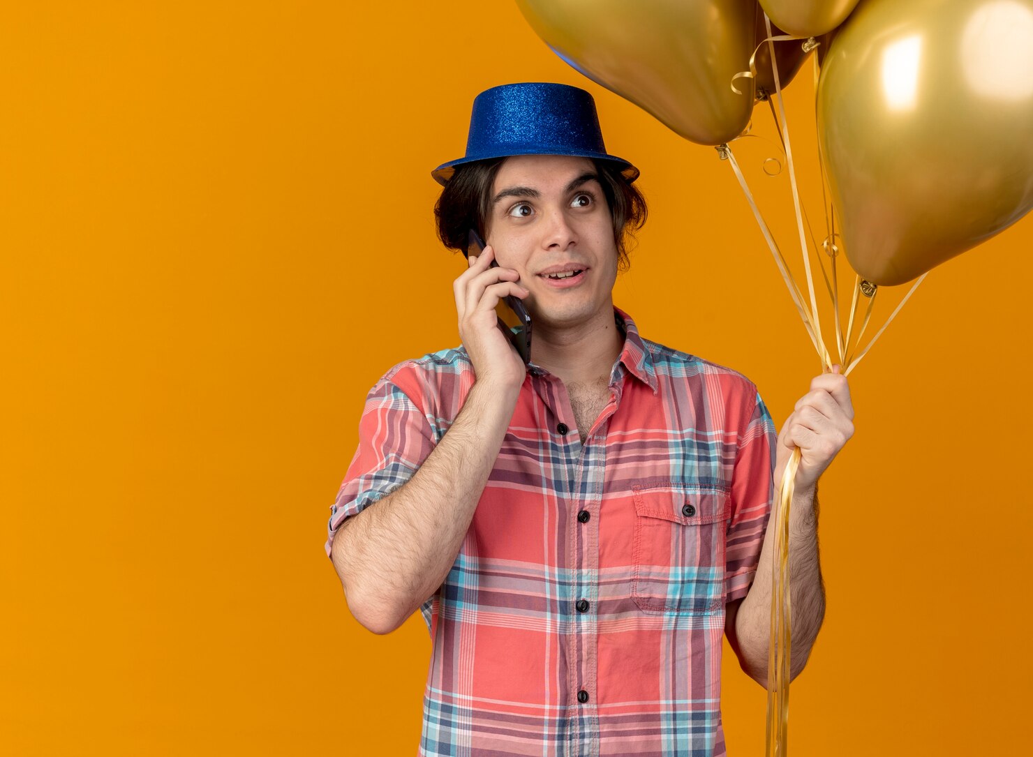 bonito-homem-caucasiano-impressionado-com-chapeu-de-festa-azul-segurando-baloes-de-helio-falando-ao-telefone_141793-99983